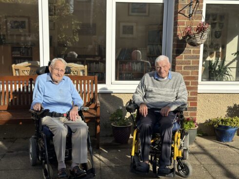 Ron and John sit outside at Care for Veterans gardens, enjoying the sunshine